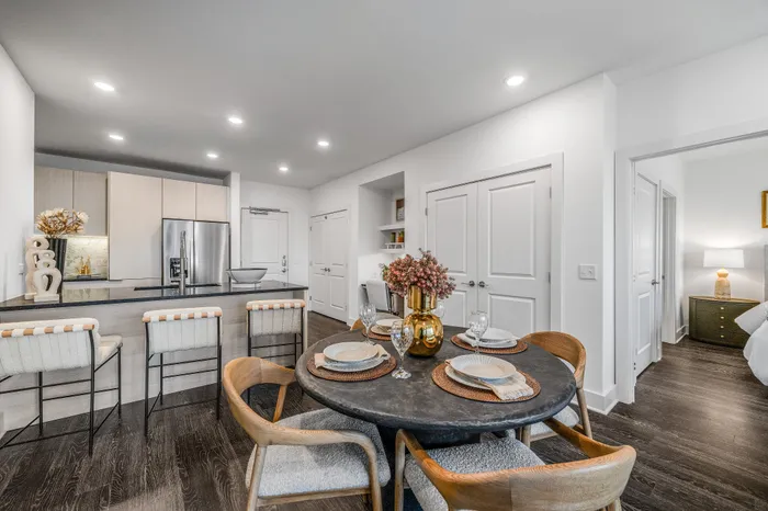 Chic open-plan kitchen and dining area with modern decor, elegant lighting, and cozy seating.