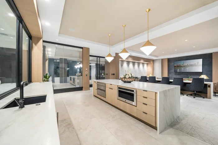 Luxurious open-concept kitchen and dining area featuring elegant lighting, sleek cabinetry, and a spacious island, perfect for entertaining.