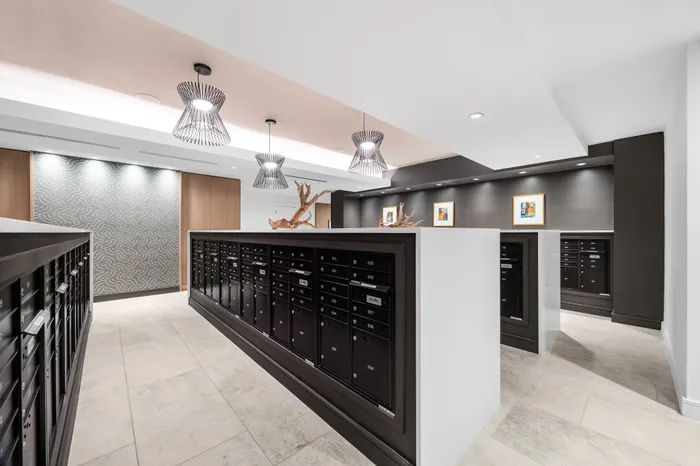 Contemporary lobby featuring sleek mailboxes, elegant lighting, and modern decor.