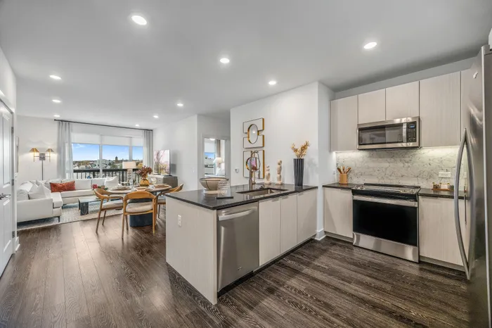 Modern open-concept apartment featuring a sleek kitchen, cozy living area with city views, and elegant dining space.