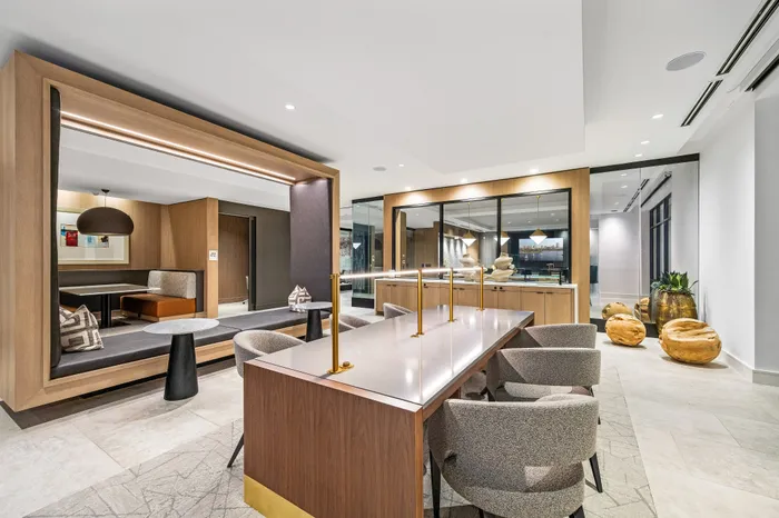 Elegant and modern communal space featuring stylish seating, sleek wooden finishes, and ambient lighting, perfect for relaxation or work.