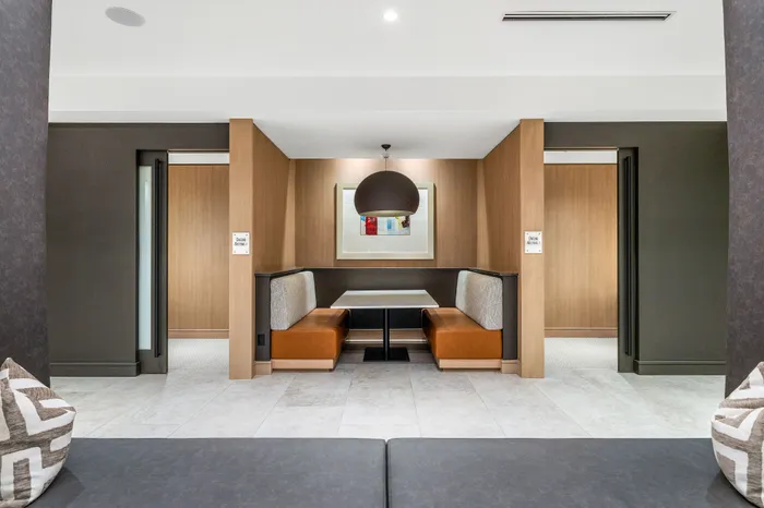 Modern and inviting seating nook with stylish wood accents and warm lighting, perfect for dining or meetings.