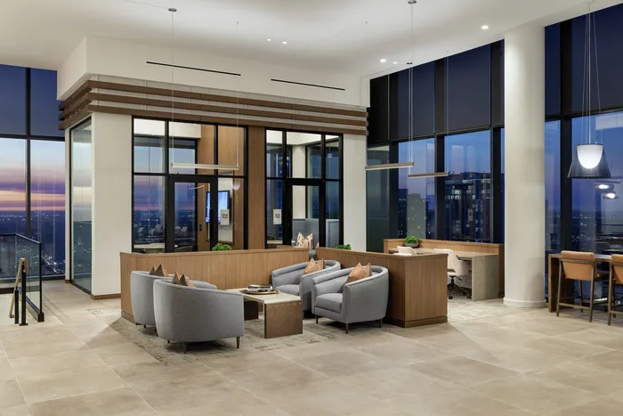 Luxurious open-concept living space with modern furnishings, large windows, and stunning city views.