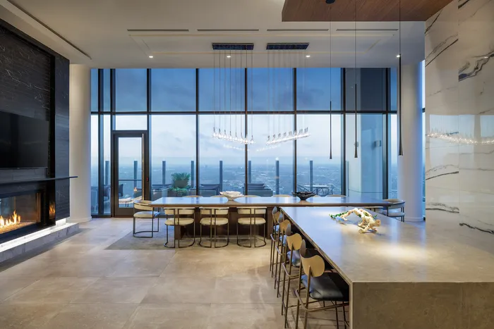 Luxurious modern dining area with panoramic city views, stylish lighting, and elegant fireplace.