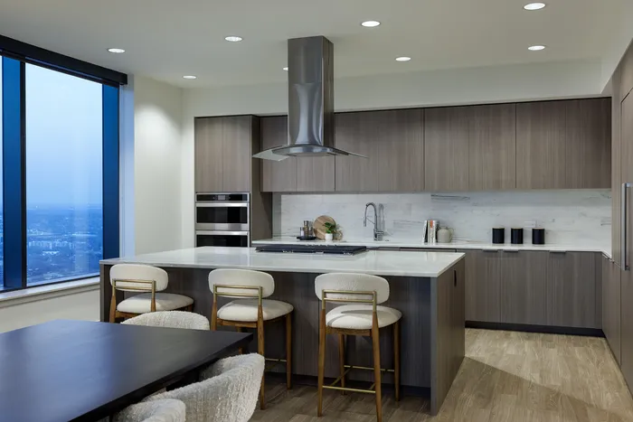 Elegant modern kitchen with sleek cabinetry, marble countertops, and panoramic city views, perfect for entertaining.