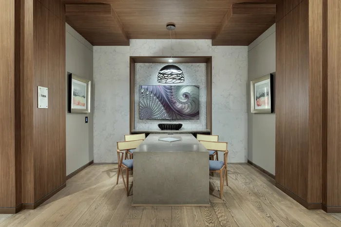Elegant dining area with contemporary design featuring wooden paneling, a stylish pendant light, and modern artwork.