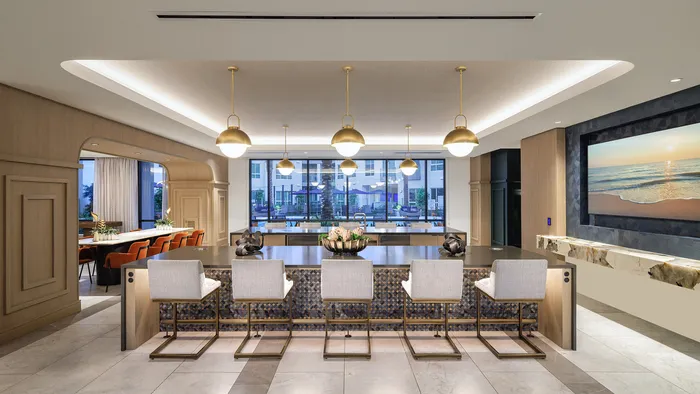 Luxurious open-concept living space with sleek kitchen island, modern pendant lights, and elegant dining area overlooking a scenic urban view.