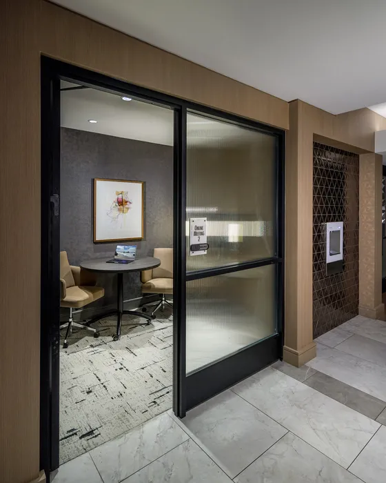 Chic office space featuring a modern round table, stylish chairs, and elegant artwork, perfect for professional meetings.