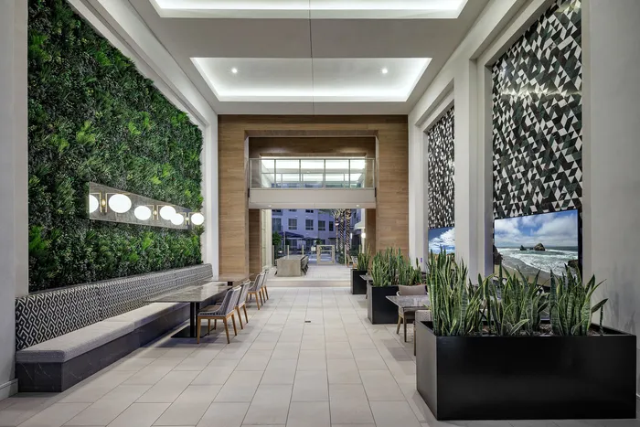 Modern lobby with lush vertical garden, stylish seating, and vibrant art pieces creating an inviting ambience.