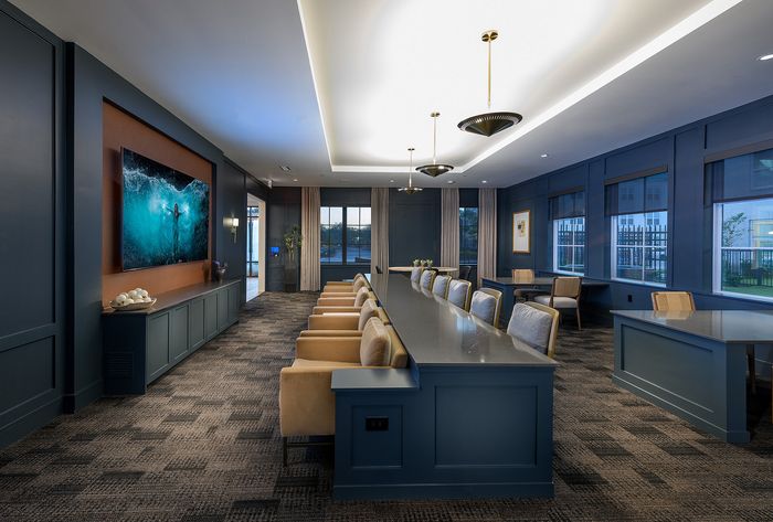 Luxurious conference area featuring a long modern table, stylish seating, ambient lighting, and elegant decor.