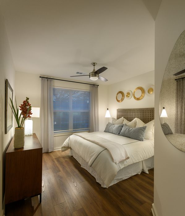 Inviting bedroom with warm wooden floors, elegant decor, and ambient lighting, offering a cozy and serene atmosphere.