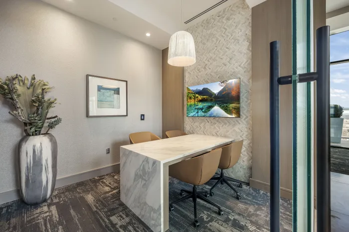 Elegant dining area with a sleek marble table, modern chairs, and a scenic wall painting, perfect for intimate gatherings.