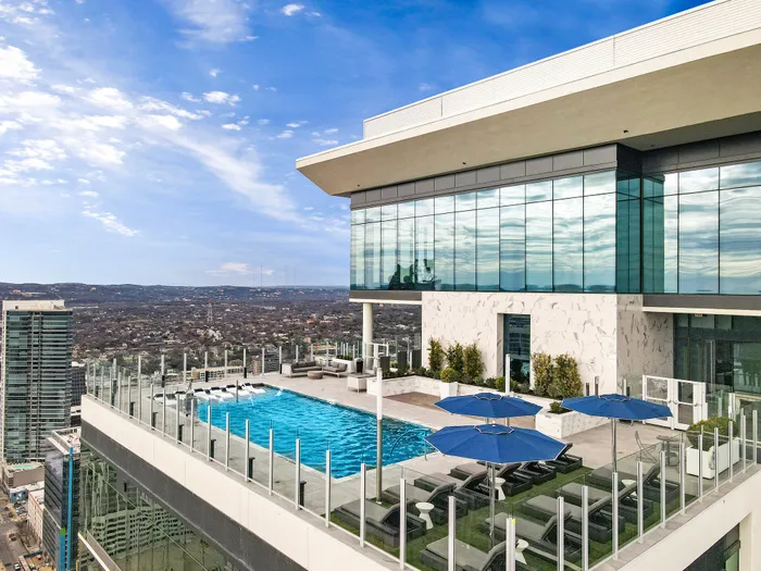 Luxurious rooftop pool with stunning city views and modern terrace seating, perfect for relaxation.