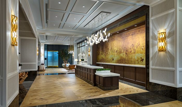 Luxurious apartment lobby with elegant lighting, sophisticated wall art, and modern furnishings.