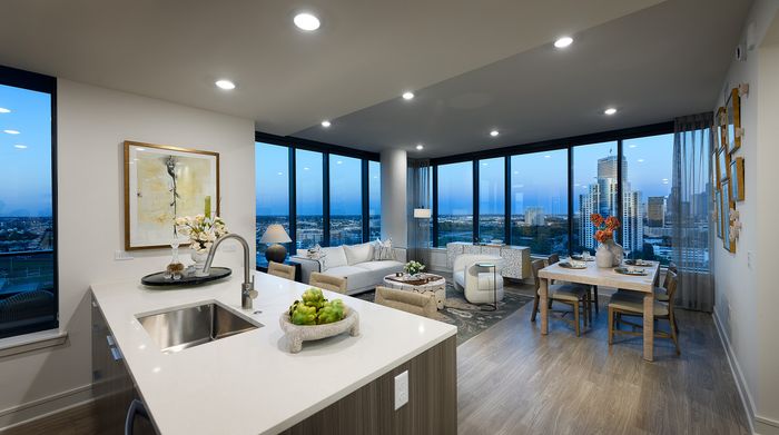 Luxury high-rise apartment with stunning cityscape views, featuring a modern open-concept living area, sleek kitchen island, and elegant dining space.