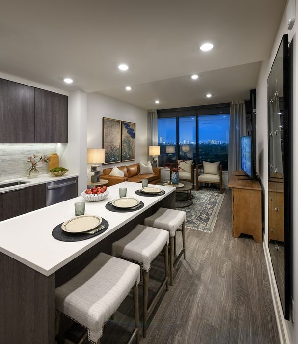 Chic apartment interior showcasing modern open kitchen, elegant living area with city view, and stylish decor.