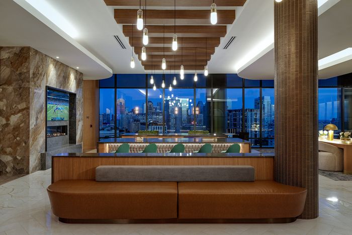 Luxurious modern apartment interior with elegant lighting, plush seating, stunning nighttime city views through expansive windows.