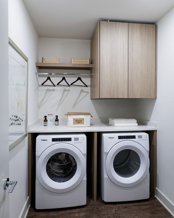 Chic laundry room with modern appliances, sleek wood cabinets, and stylish decor accents.