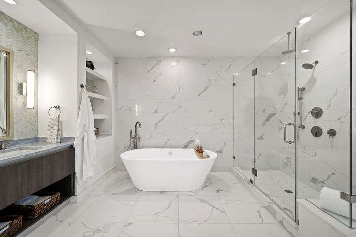 Luxurious bathroom featuring a freestanding tub, elegant marble tiles, and a spacious glass shower enclosure.