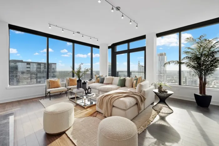Luxurious high-rise living room with panoramic city views, modern decor, and abundant natural light.