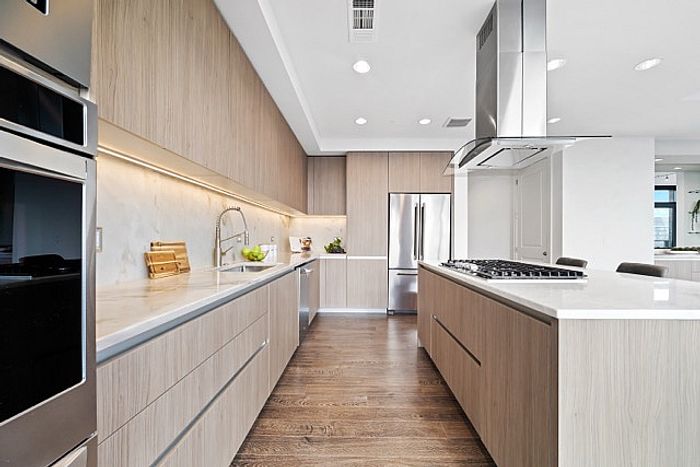 Sleek modern kitchen with elegant wooden cabinetry, high-end stainless steel appliances, and luxurious marble countertops.