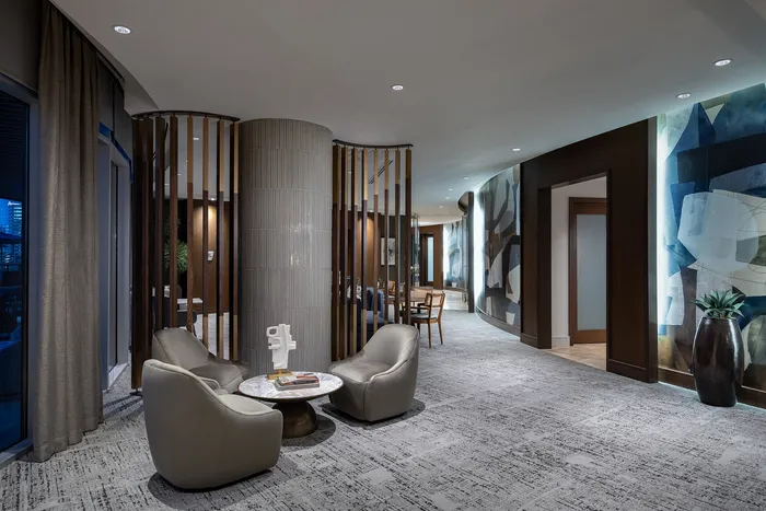 Elegant contemporary lounge area featuring modern seating, artistic lighting, and sophisticated design elements in a luxurious apartment building.
