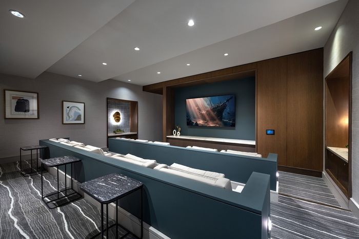 Luxurious home theater with plush seating, modern art, and sleek design, perfect for cinematic experiences.