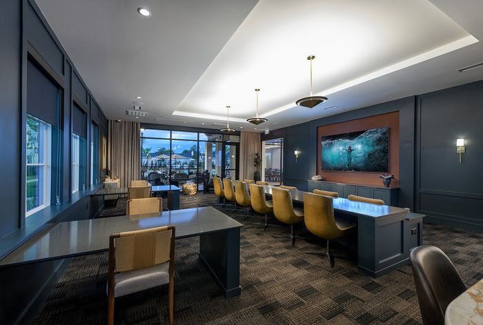 Modern, well-lit communal lounge with stylish seating and vibrant decor, overlooking a scenic outdoor area.
