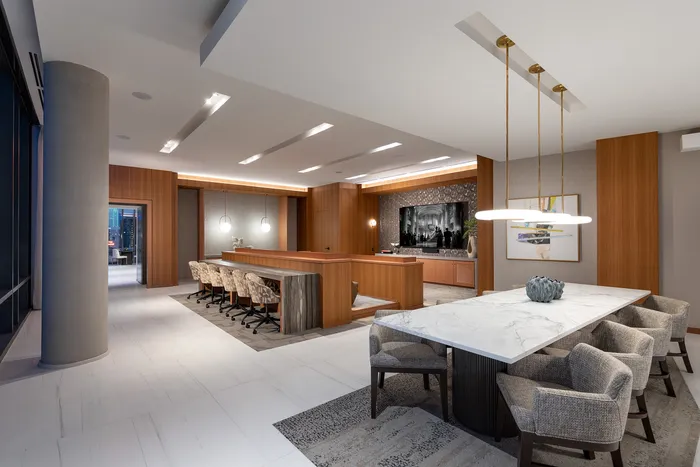 Sophisticated dining room with modern marble table, chic pendant lighting, and elegant wood accents in a luxury apartment.