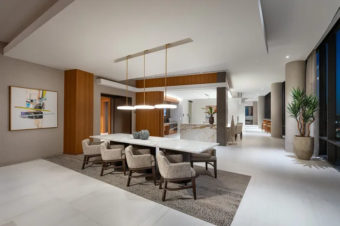 Luxurious open-plan dining and living area with elegant lighting, modern decor, and large windows showcasing stunning views.