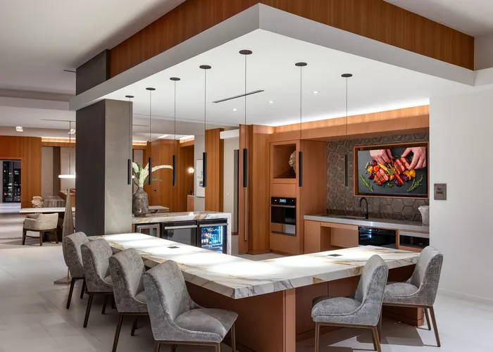 Luxurious contemporary kitchen with elegant marble countertops, modern appliances, and stylish pendant lighting in an open-plan setting.