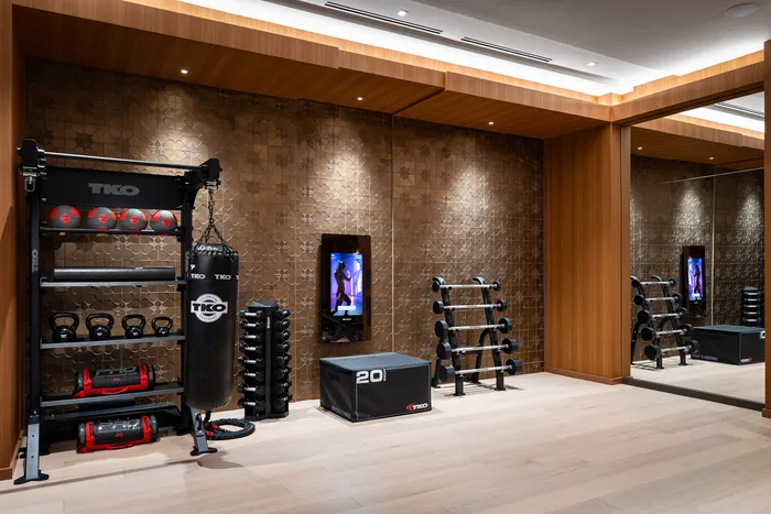 Luxurious home gym with modern equipment, sleek wooden finishes, and ample space for a personalized workout experience.