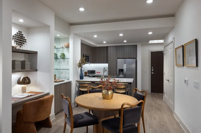 Elegant modern kitchen and dining area featuring sleek cabinetry, ambient lighting, and stylish decor.