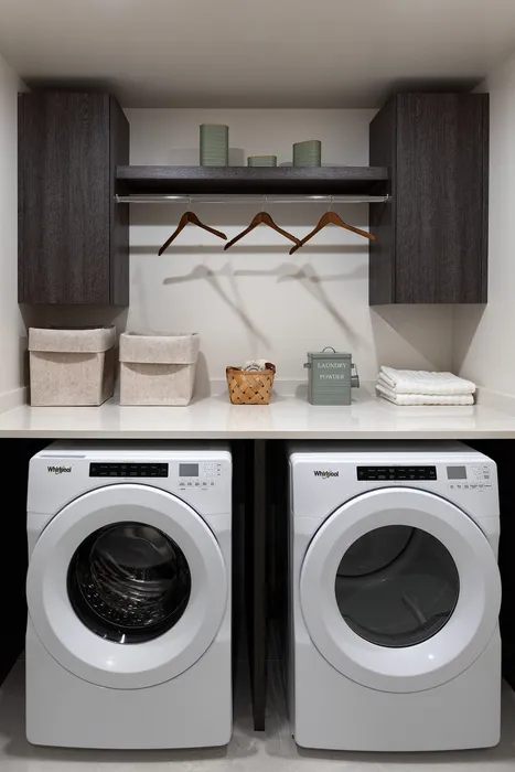 Modern laundry room featuring sleek cabinetry, high-efficiency washer and dryer, and stylish storage solutions.