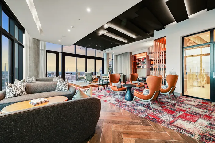 Luxurious open-concept living space with elegant seating, floor-to-ceiling windows, and cityscape views.