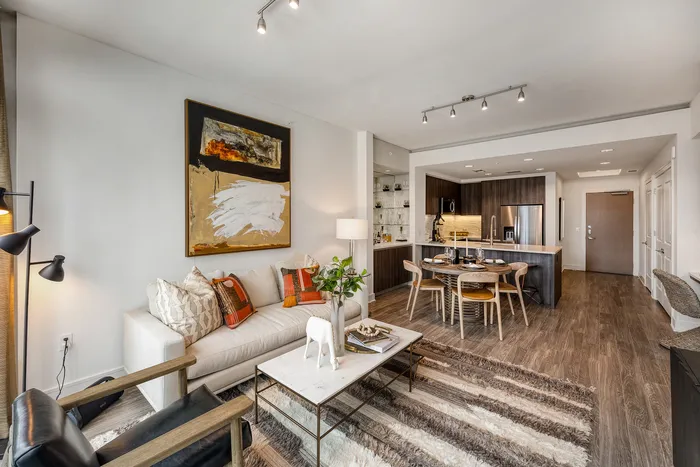 Contemporary open-plan living area featuring stylish decor, a cozy seating arrangement, and a modern kitchen with elegant dining space.
