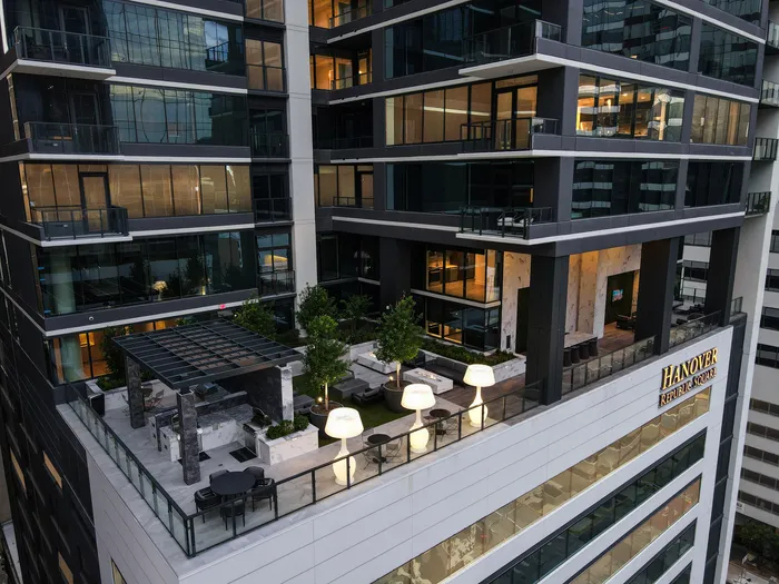 Modern high-rise with luxurious rooftop terrace, featuring stylish outdoor seating and ambient lighting at Hanover Republic Square.