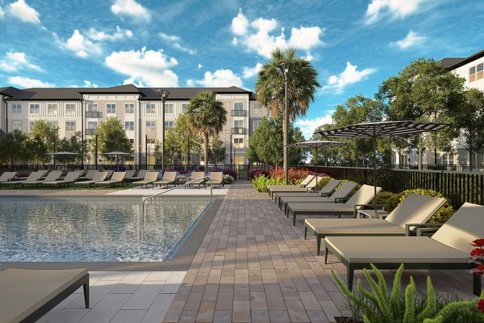 Luxurious apartment complex poolside with stylish lounge chairs and umbrellas, surrounded by lush greenery and modern architecture under a vibrant blue sky.