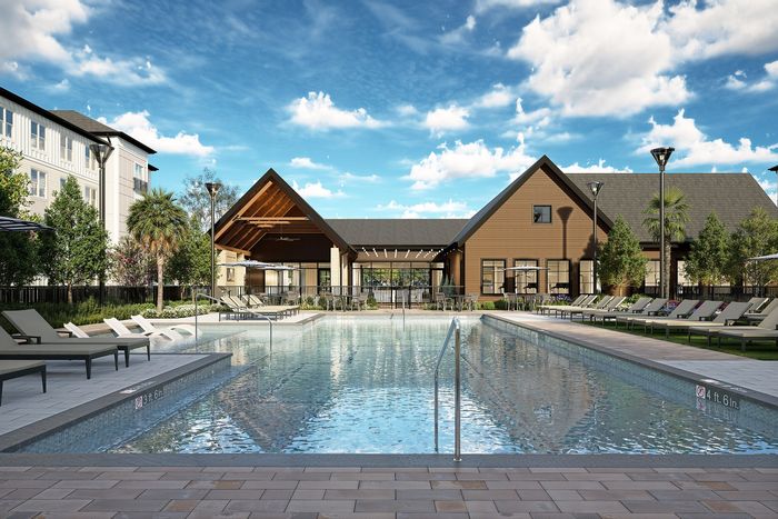 Luxurious community pool with elegant lounge chairs, surrounded by lush greenery and modern architecture under a bright blue sky.