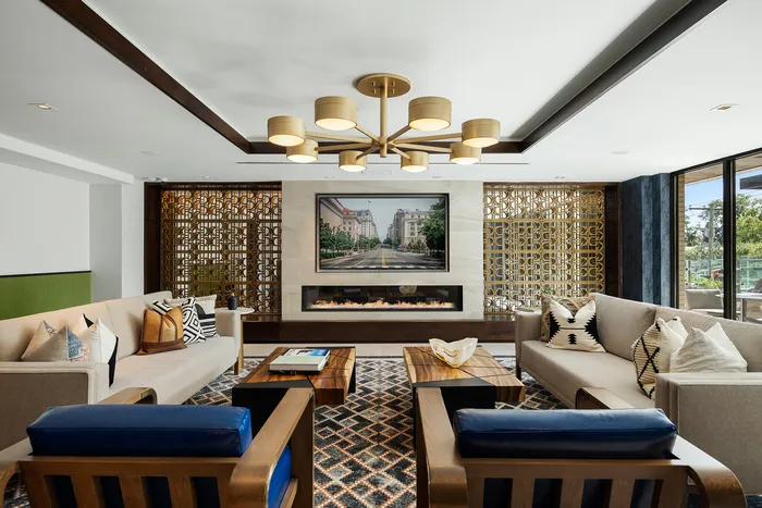 Sophisticated living room with modern decor, featuring elegant couches, a stylish chandelier, and a contemporary fireplace, perfect for relaxation.