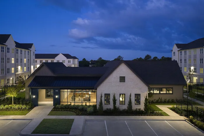 Charming apartment complex at dusk, showcasing elegant architecture and inviting community spaces.