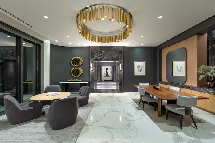 Luxurious modern dining area with elegant marble floors, stylish seating, and a stunning gold chandelier centerpiece.