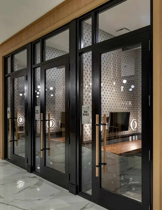 Modern meeting rooms with chic wallpaper and sleek glass doors, perfect for online collaboration.