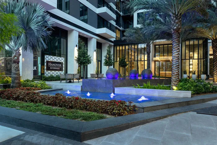 Luxurious apartment entrance featuring elegant landscaping and striking water fountains at Hanover Riverwalk.