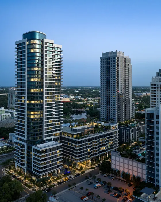 Modern high-rise building panorama at dusk, showcasing luxurious urban architecture with surrounding city views.