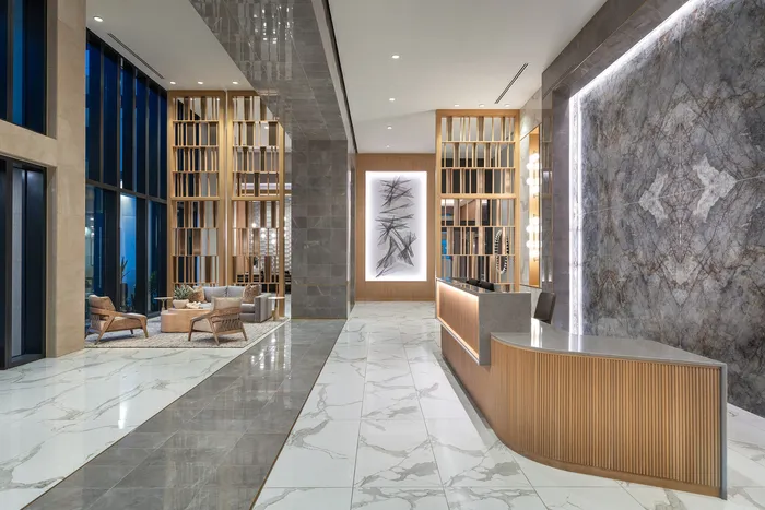 Luxurious apartment lobby with modern marble floors, elegant wooden accents, and stylish furniture.