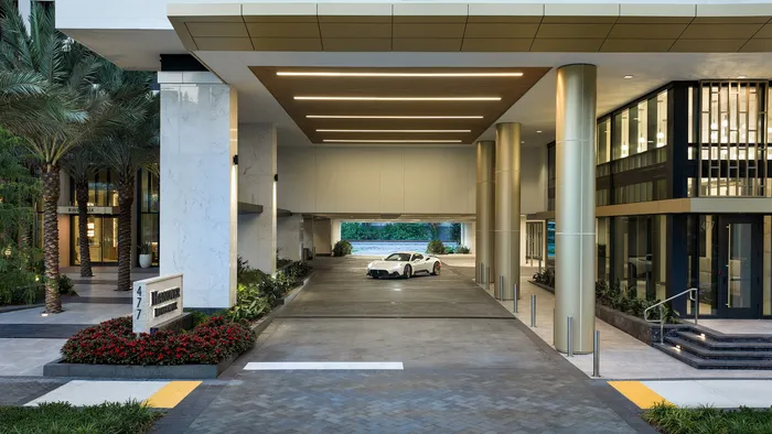 Luxurious entrance of Hanover Riverwalk with sleek architecture, elegant lighting, and a stylish courtyard featuring a contemporary white car.
