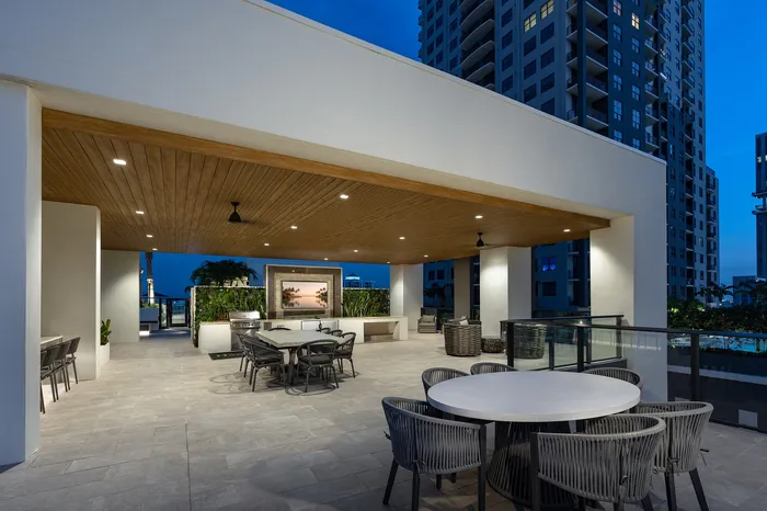 Luxurious rooftop patio featuring ambient lighting, elegant seating, and a stunning city view, perfect for entertaining.