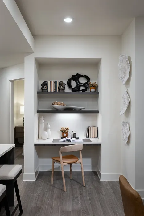 Modern home office nook with sleek shelves, chic decor, and a cozy ergonomic chair, perfect for productivity.