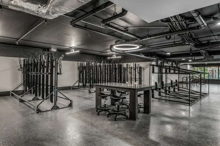 Modern bike storage facility with sleek design, ample racks, and a stylish table setting under ambient lighting.